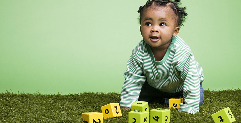 A photo of an infant with blocks