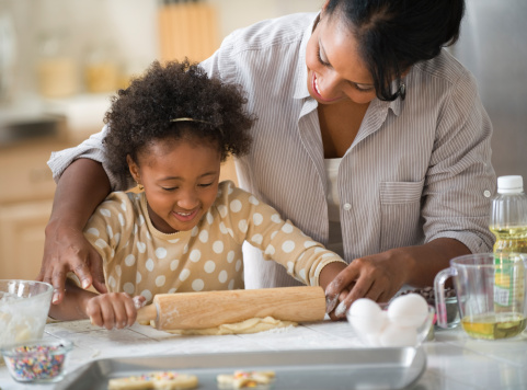 Young girl baking with mother.