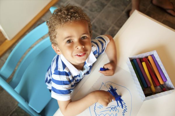 kid coloring with blue marker
