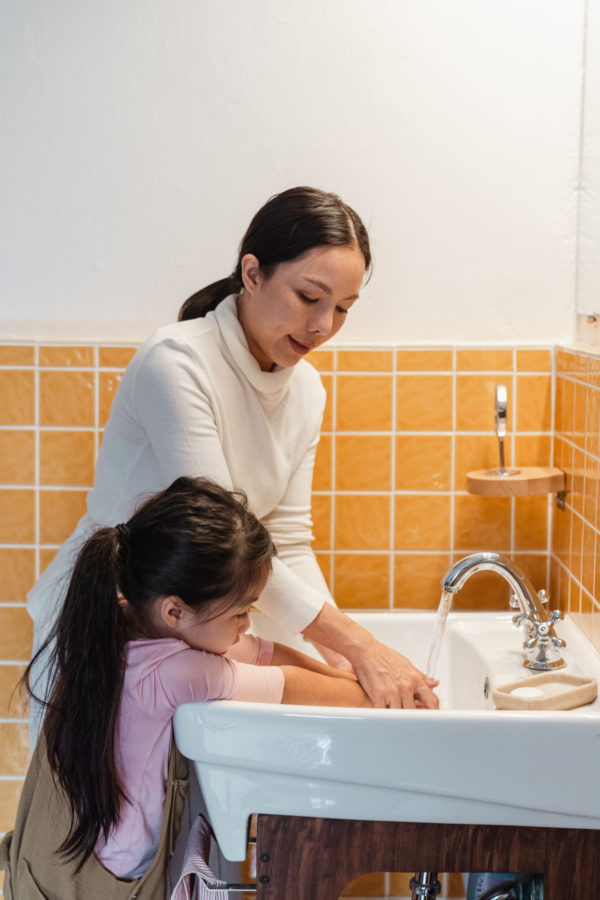 mom teaching daughter to wash hands